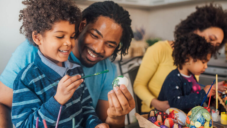 Family decorating Easter eggs together for their family tradition