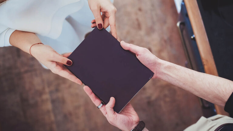 Man and woman's hands holding a couples journal for their spring activity