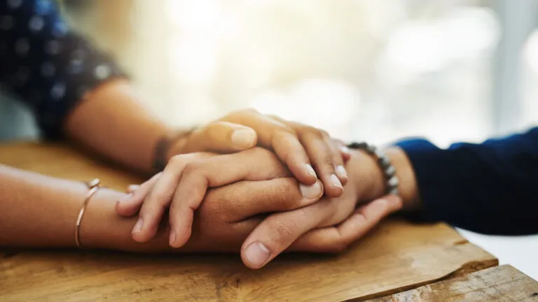 Two people holding hands in forgiveness for their Easter tradition