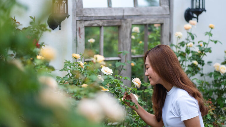 Woman takes up the spring activity to stop and smell the roses