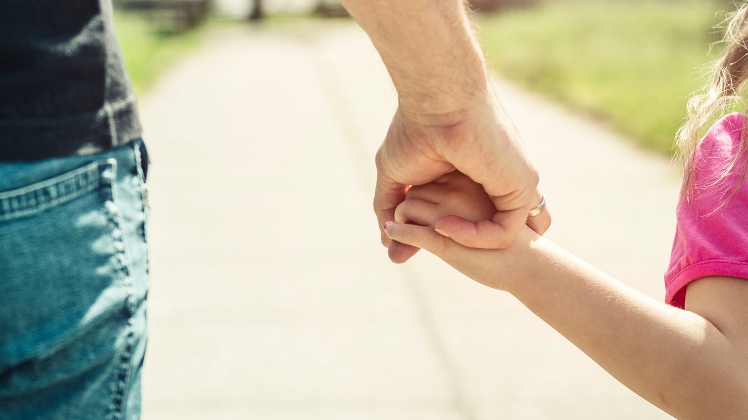 A father holds his child's hand